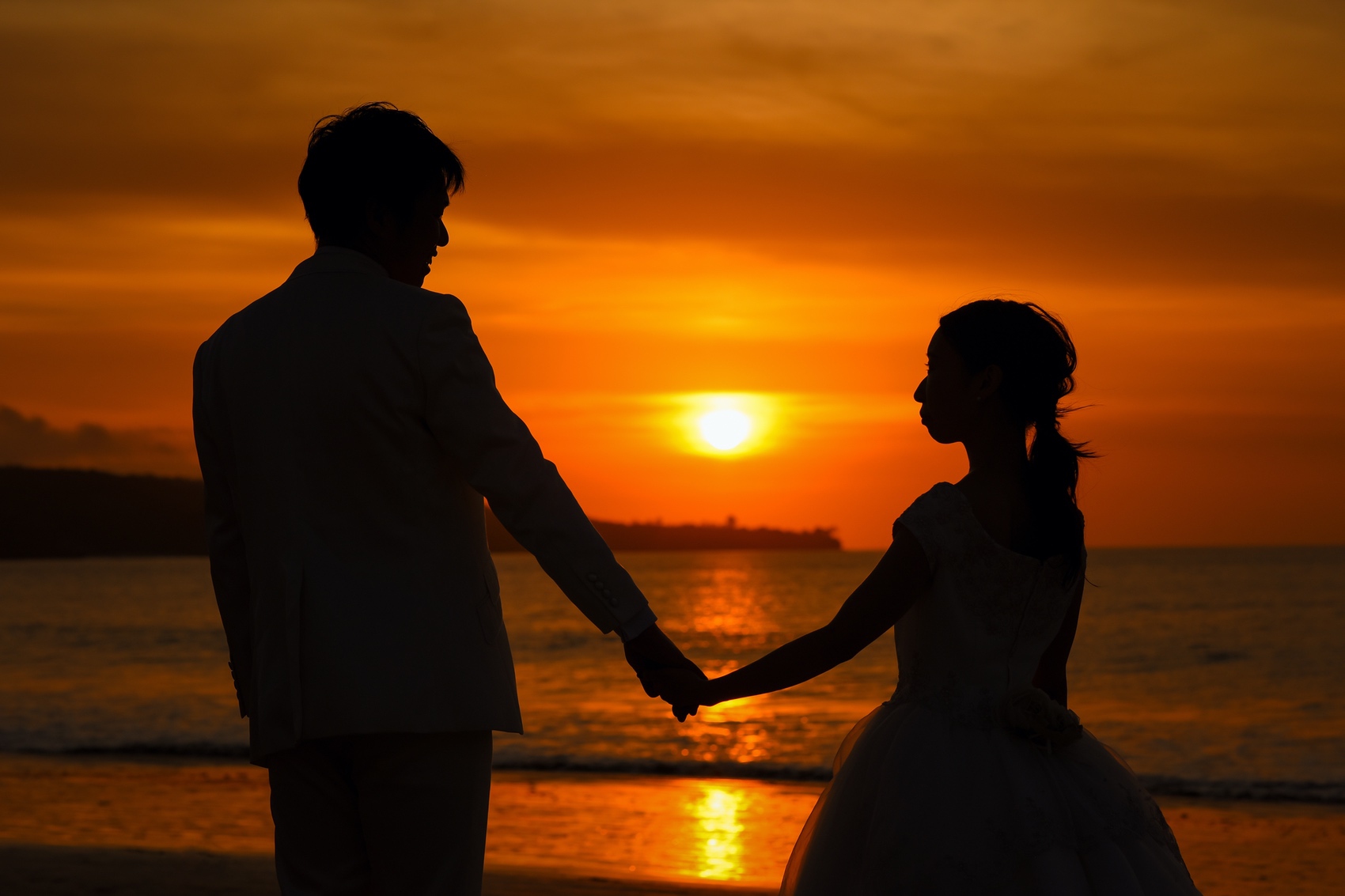 夕日の前で手を繋いで