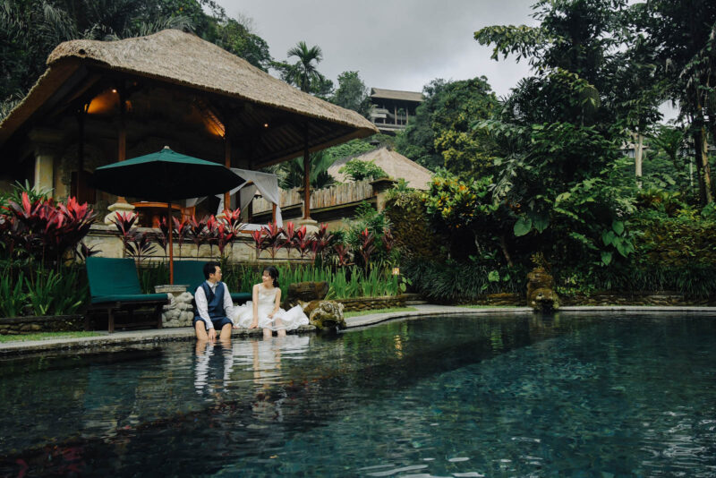 ロイヤルピタマハのプールサイドで座る新郎新婦