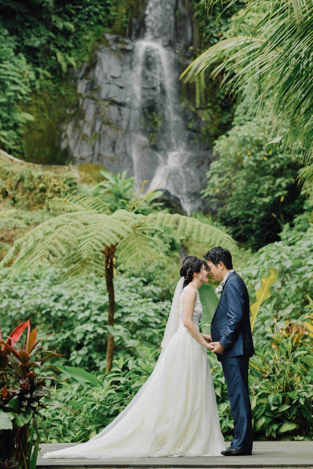 滝の前で見つめ合う新郎新婦のアップショット
