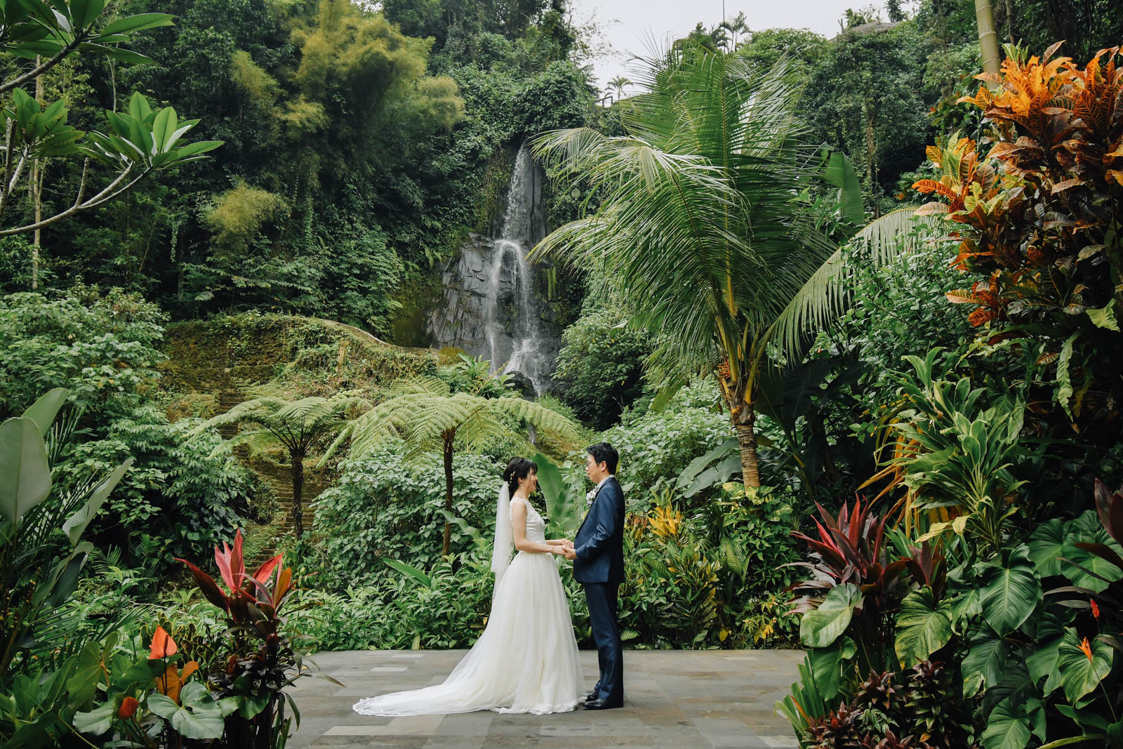 滝を背景に立つロイヤルピタマハでの新郎新婦