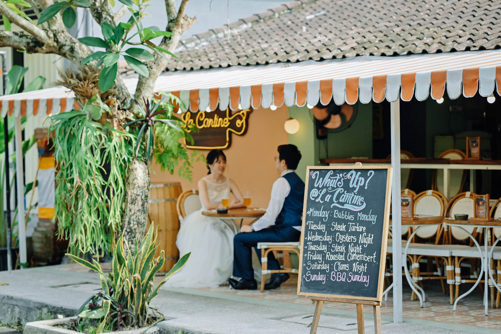ウブドの街角カフェ「La Cantine」の外観で撮影する新郎新婦