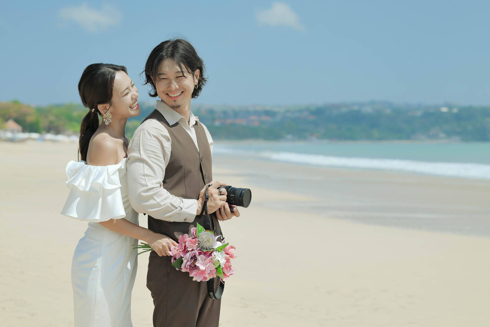 バリ島フォトウェディング、海風を感じながら笑顔を見せる新郎新婦