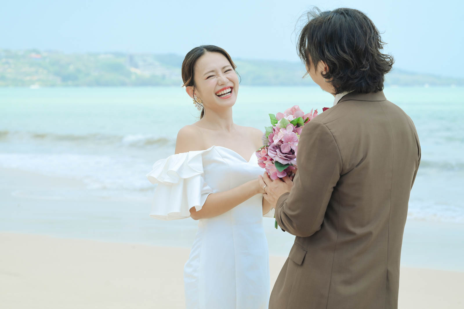 バリ島ジンバランビーチで笑顔を交わす新郎新婦の自然体ショット