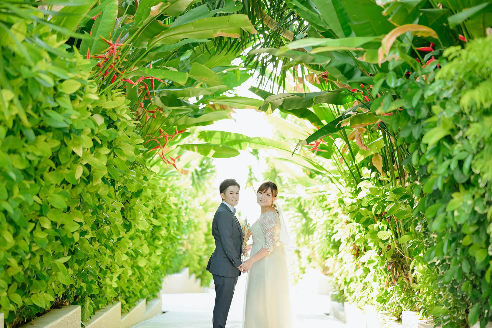バリ島の緑に囲まれたガーデンで手を取り合う新郎新婦のウェディングフォト